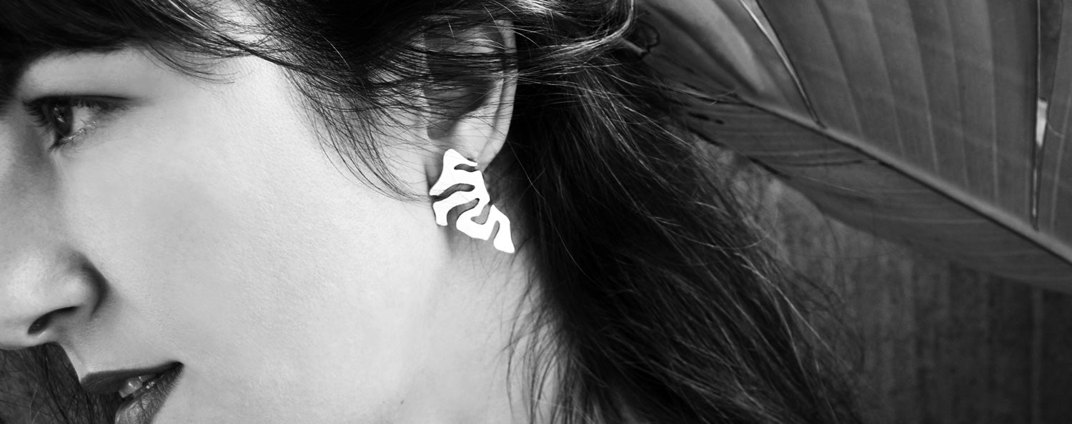 Close up of a woman wearing a silver abstract earring