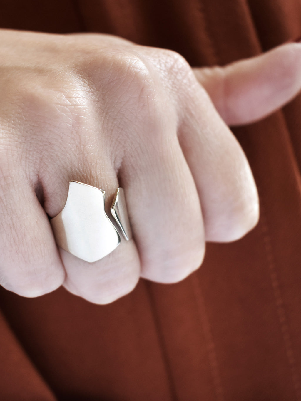 Close-up of a hand wearing an adjustable sculptural silver ring