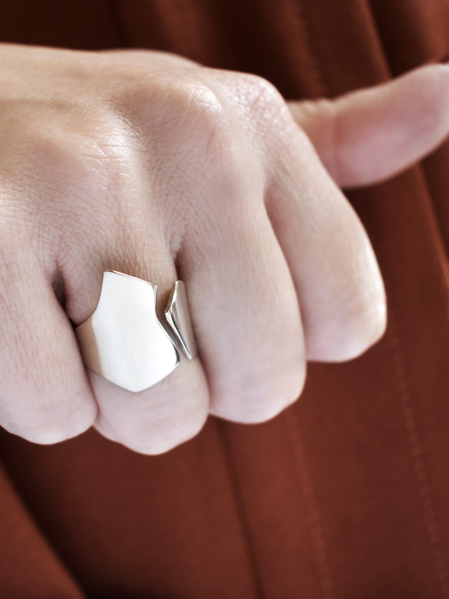 Close-up of a hand wearing an adjustable sculptural silver ring