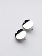 Pair of small circle silver stud earrings on a light gray background