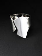 Adjustable sculptural silver ring on a black background