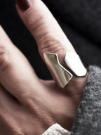 Close-up of a hand wearing an adjustable sculptural silver ring