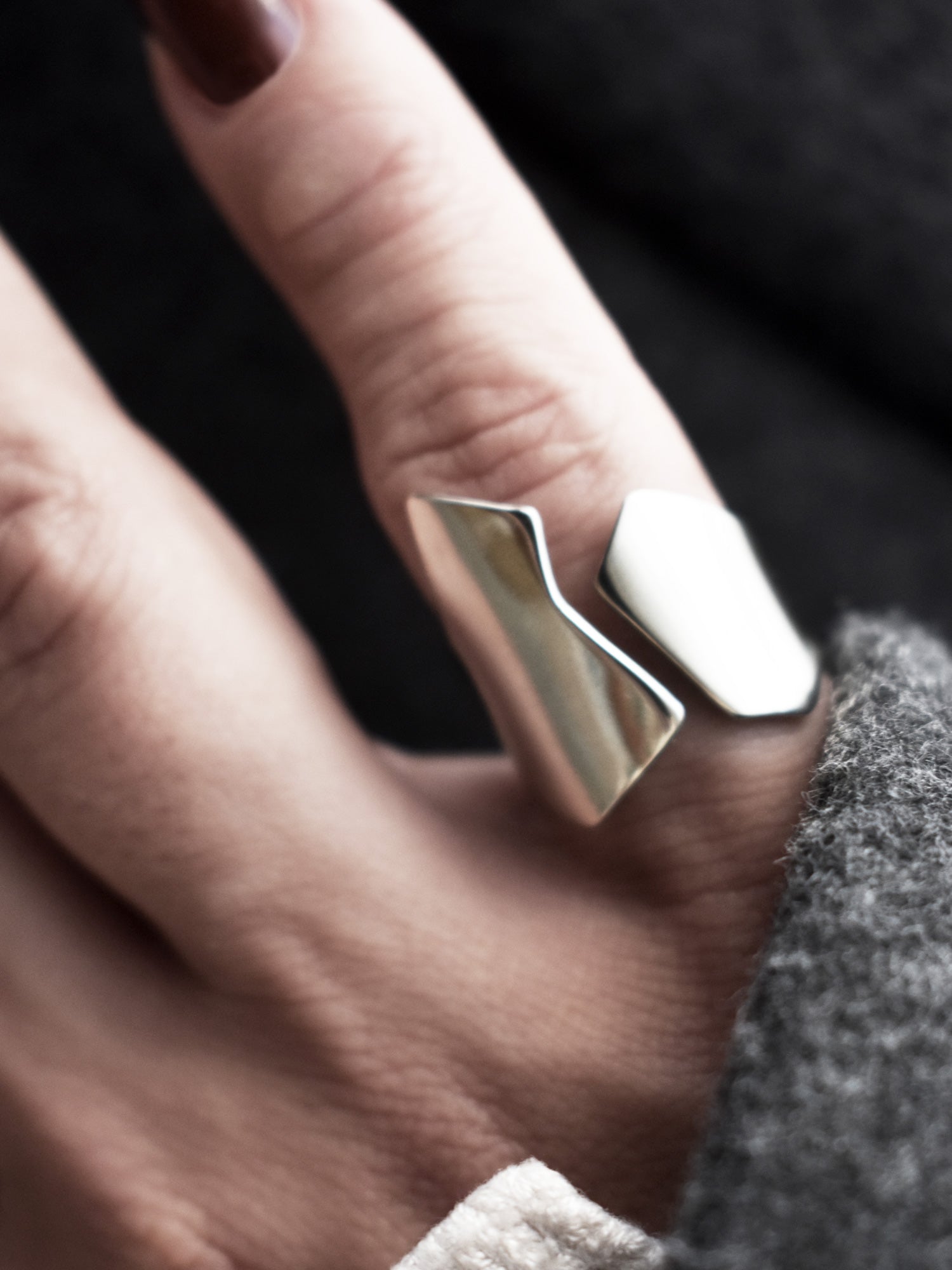 Close-up of a hand wearing an adjustable sculptural silver ring