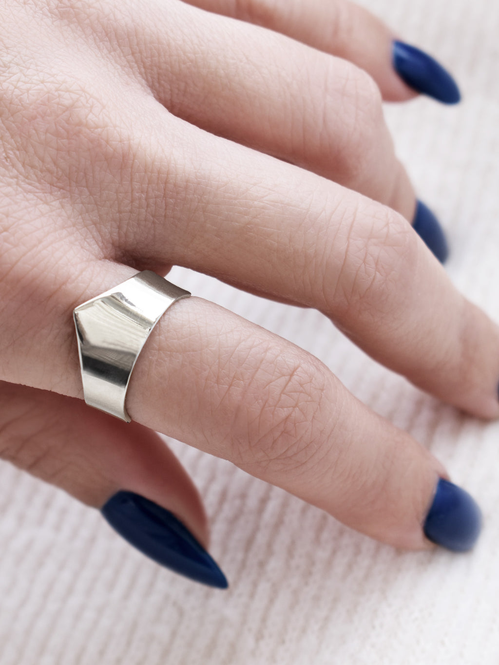 Close-up of adjustable silver ring with an angular band on a woman's hand