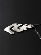Silver leaf-shaped pendant with chain on a black background