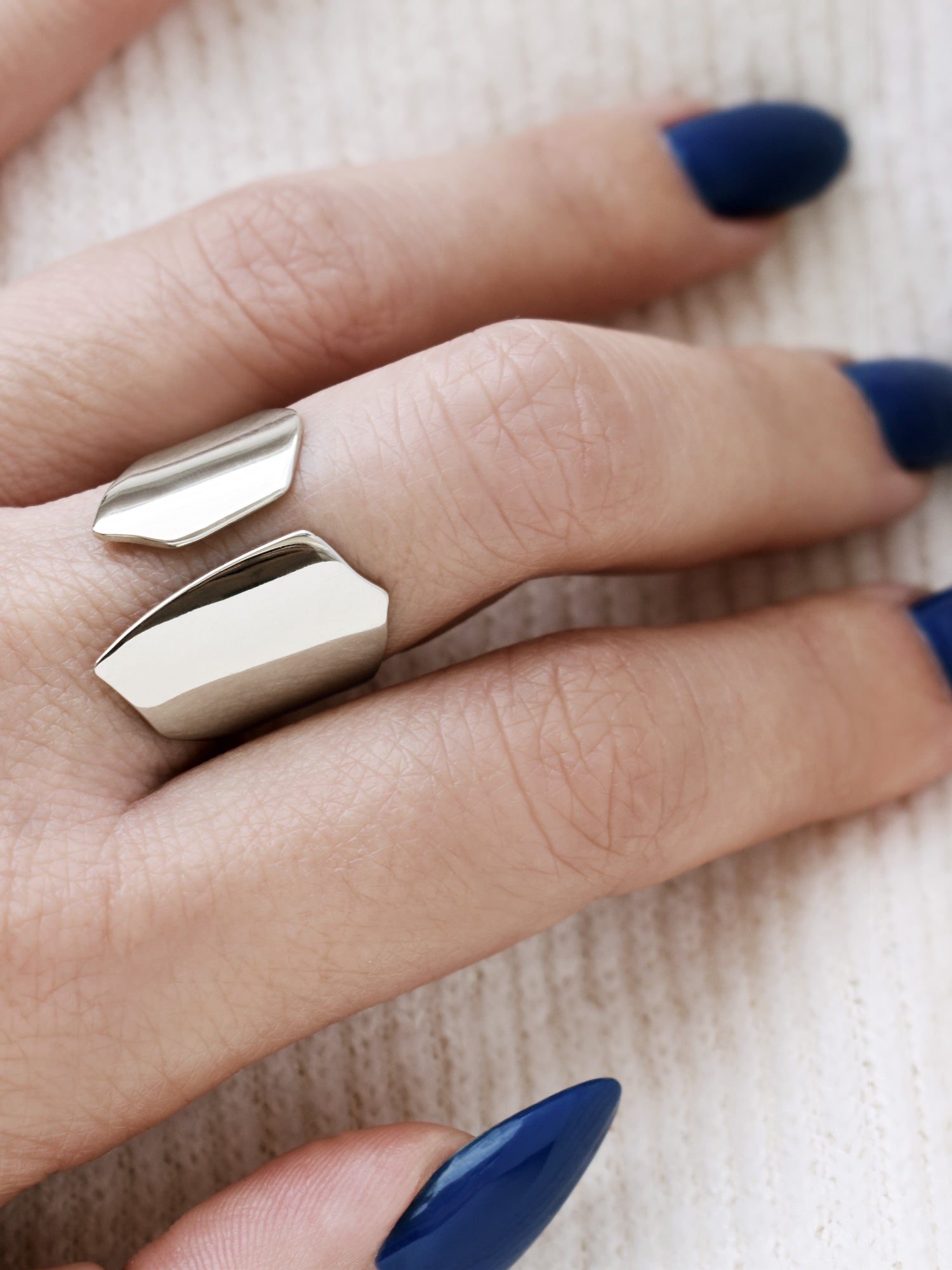 Close-up of a hand wearing an adjustable sculptural silver ring