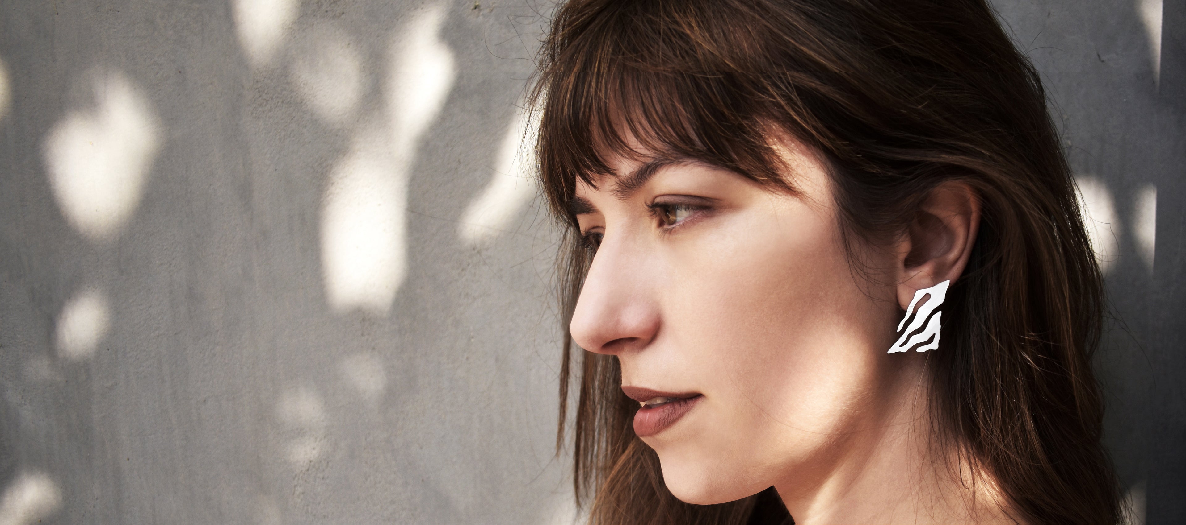 Woman wearing a silver abstract earring