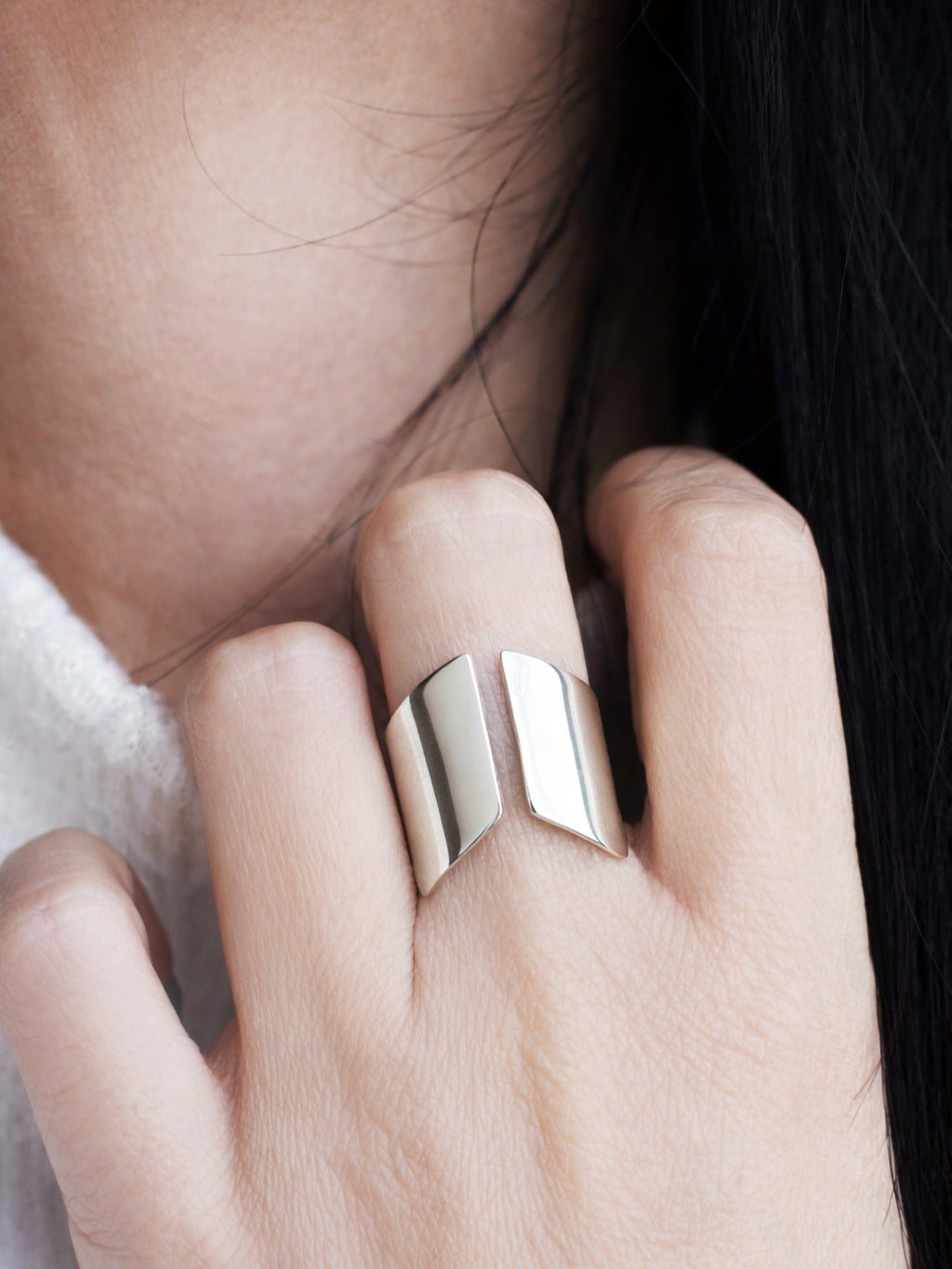 Close-up of an adjustable sculptural silver ring on a woman's hand