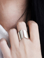 Close-up of an adjustable sculptural silver ring on a woman's hand